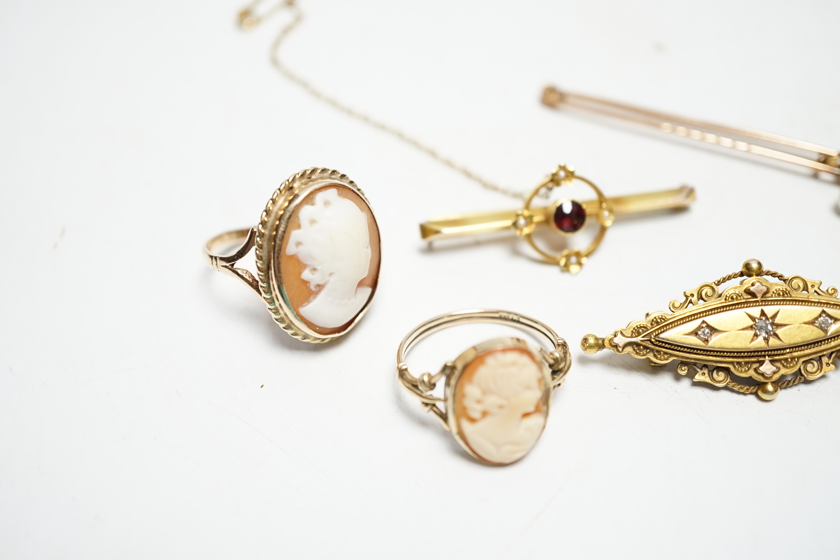A late Victorian 15ct gold and three stone diamond chip set brooch, 43mm, an early 20th century yellow metal, garnet and seed pearl set bar brooch, two 9ct and oval cameo shell set rings and a yellow metal and cultured p